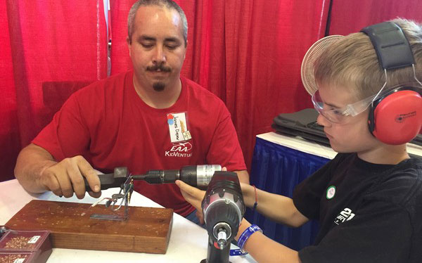 Owen Stieg of Illinios, age 10, learns how to rivet from KidVenture volunteer James Depew. Photo by Julia Lammers.